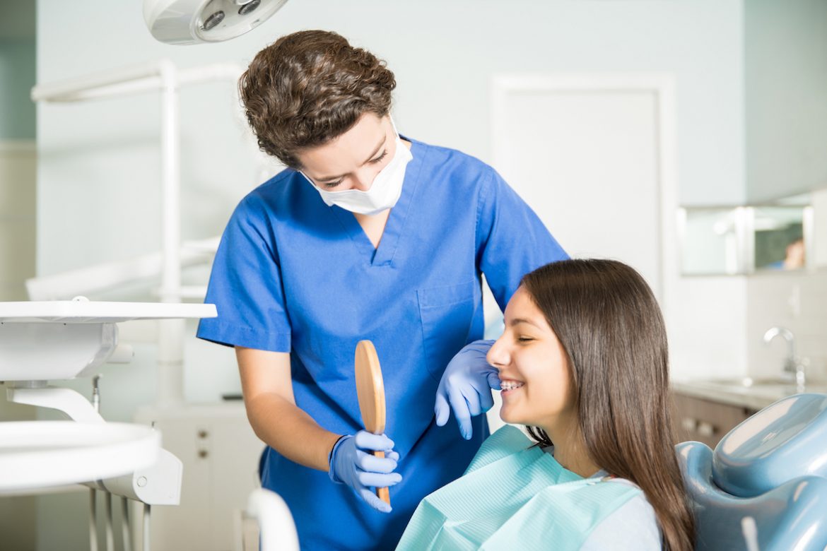 dentist showing a teenager her smile