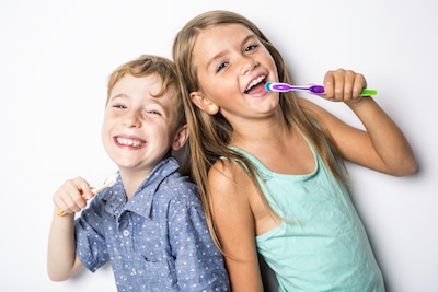 sister and brother brushing teeth